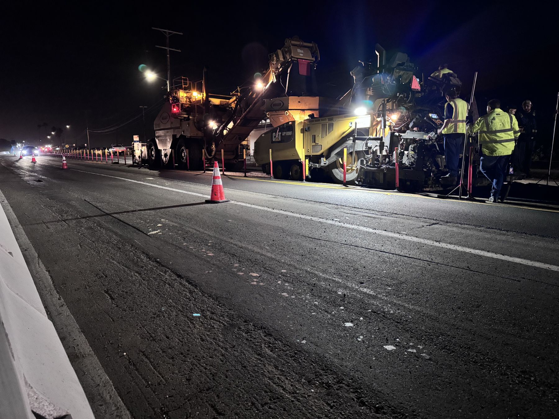 Night asphalt paving train laying a fresh mat